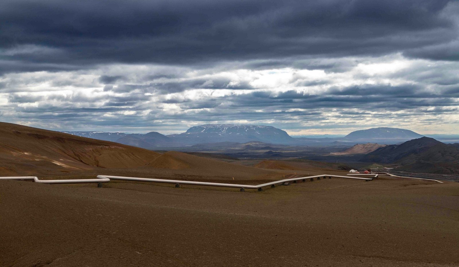 a dirt field with mountains in the background